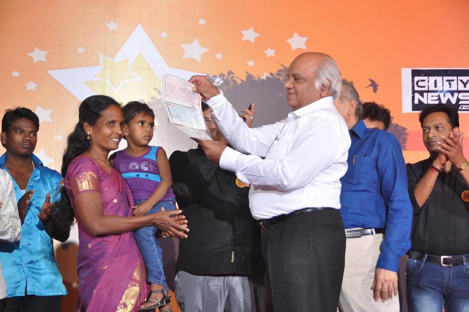 Rajendra Parekh presenting a certificate to a participant on stage